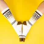 Close-up lifestyle shot of model wearing rainbow 'Love' socks. [lf]