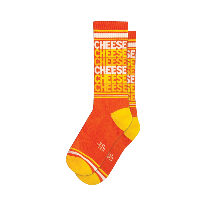 Pair of orange crew socks with a repeating 'CHEESE' pattern in a lighter orange and white. Yellow stripes are visible at the top and bottom cuffs.