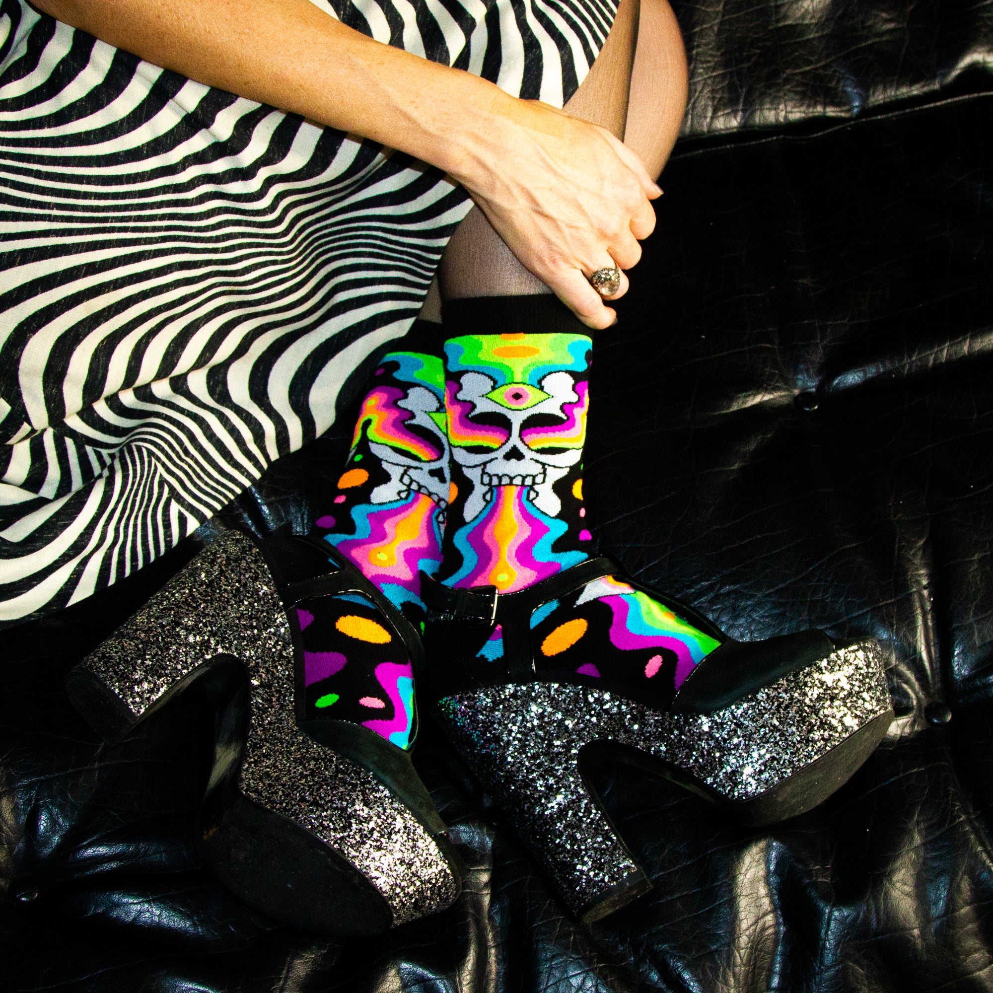 Lifestyle shot: A person wearing Eye of the Doomed socks with platform shoes, showing off the socks' vibrant psychedelic design. [lf]