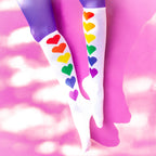 Flatlay: Pair of Rainbow Hearts socks on a pink background. [lf]