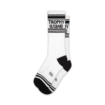 white crew xl socks with black stripes and heels. 'trophy husband' written in black on white part of the sock.   