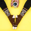 Flatlay product photo of the socks and a coffee mug on a yellow background. [lf]