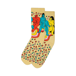 Cream-colored crew socks featuring a whimsical cartoon design of colorful figures on a rainbow, surrounded by small multicolored stars.