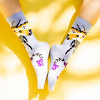 Flat lay shot of Bee & Flowers socks on a yellow background. [lf]