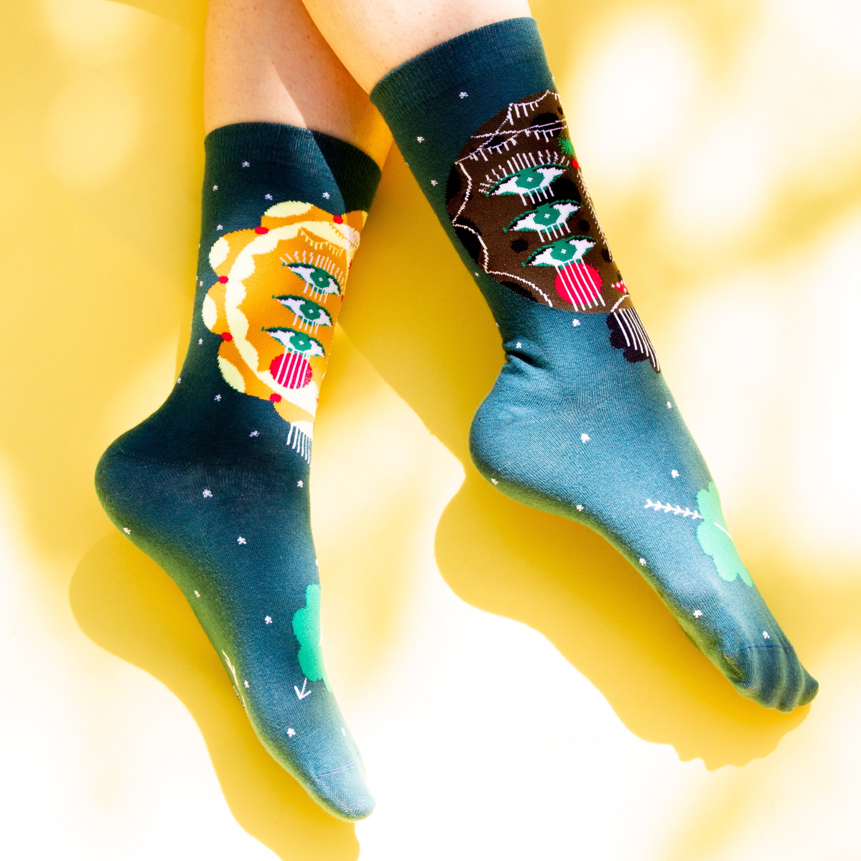 Flat lay shot showing Sun & Moon socks on a bright yellow surface, highlighting the sock's design and color details. [lf]