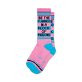 Pair of pink crew socks with teal accents and the phrase 'Be the flamingo in a flock of pigeons' in black.