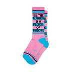 Pair of pink crew socks with teal accents and the phrase 'Be the flamingo in a flock of pigeons' in black.