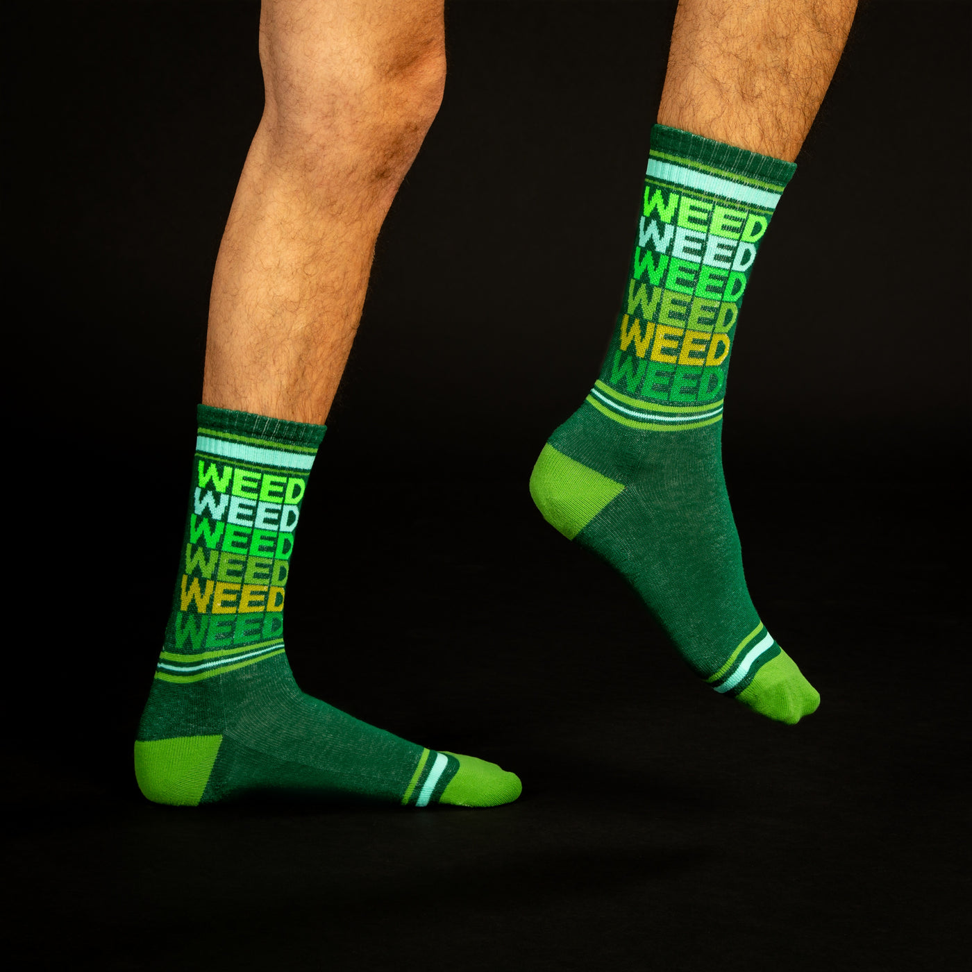 Lifestyle shot: A person's legs wearing the 'Weed' socks against a black background. The socks' design is clearly visible. [lf]