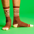 Lifestyle shot showing the socks on a person's legs against a bright green background. [lf]