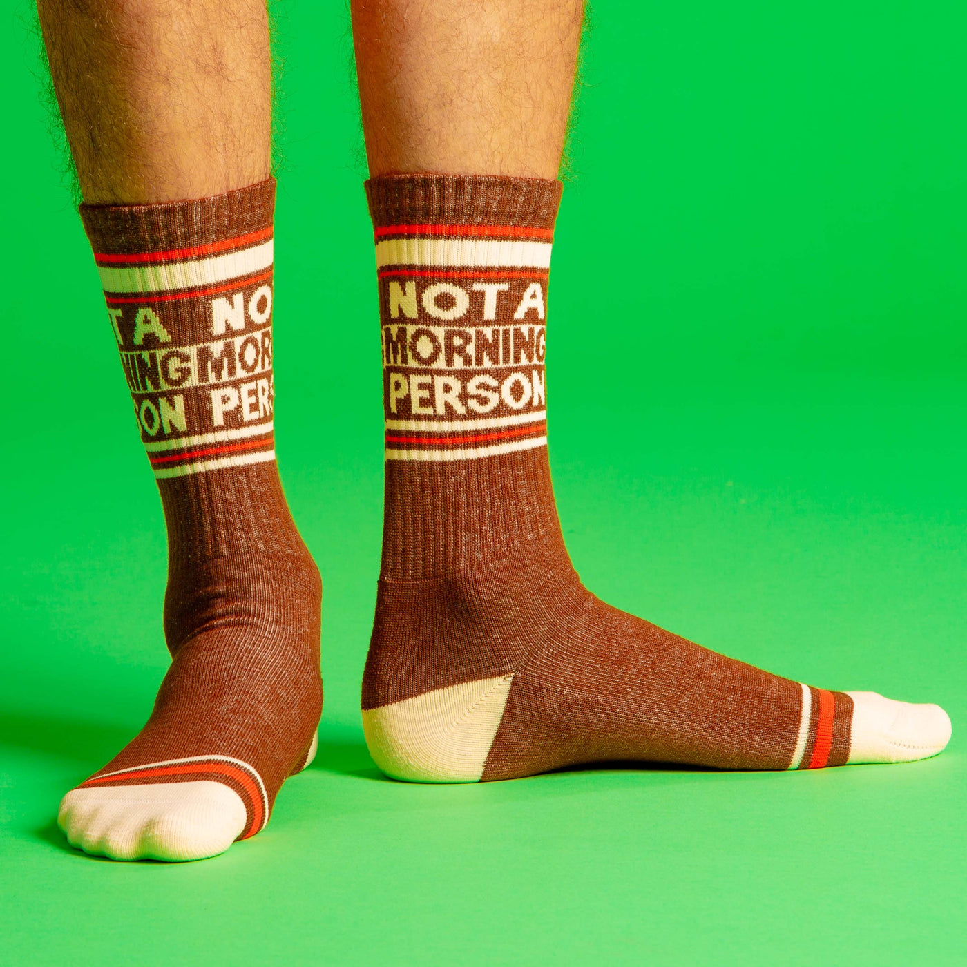 Lifestyle shot showing the socks on a person's legs against a bright green background. [lf]