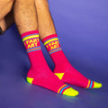 Lifestyle shot of a person's legs wearing the 'I Fart Art' socks. The socks are pink with neon yellow accents.