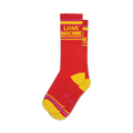 Pair of red crew socks with yellow and purple stripes and 'LOVE MACHINE' in yellow text.