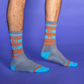 Lifestyle shot of a person's legs wearing the 'I'm in no shape to exercise' socks against a purple background. [lf]