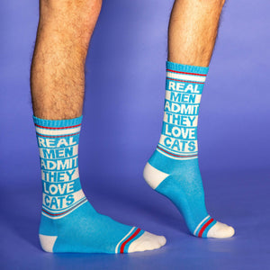 A pair of blue socks with white toes, heels, and red and white striped cuffs. The socks have the words 