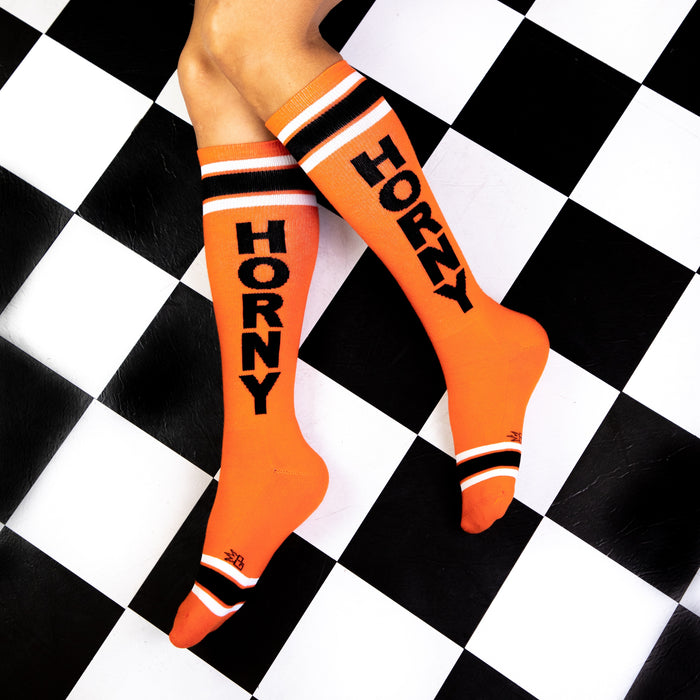 A pair of orange knee-high socks with the word 