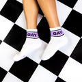 A flatlay of a person wearing the socks on a black and white checkered floor. [lf]
