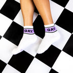 A flatlay of a person wearing the socks on a black and white checkered floor. [lf]