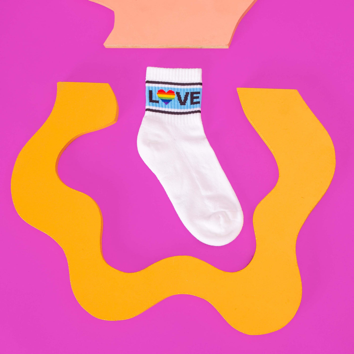 Close-up of a single white 'Love' sock on a pink and yellow background. [lf]