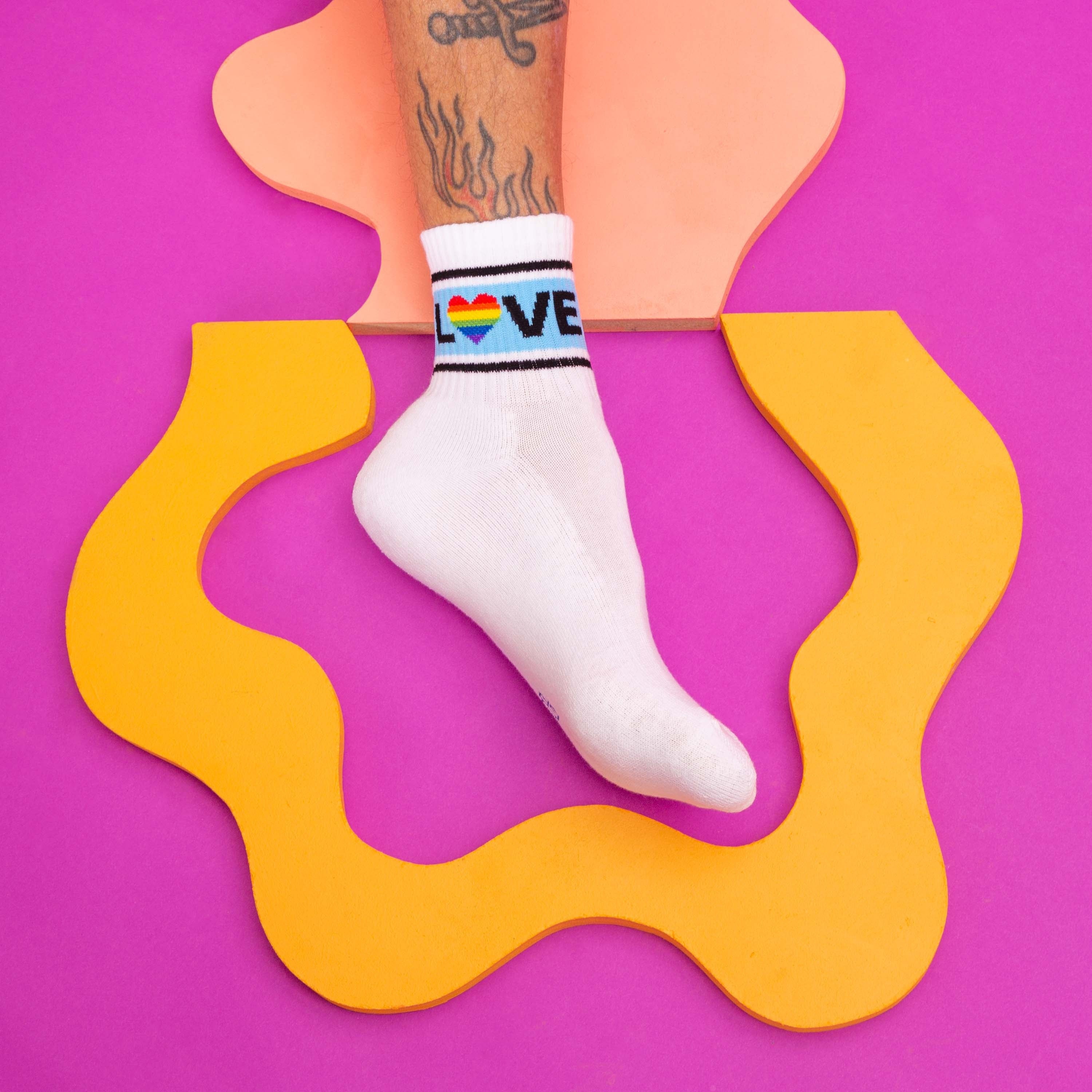 Lifestyle shot of a person's foot wearing one 'Love' sock. [lf]