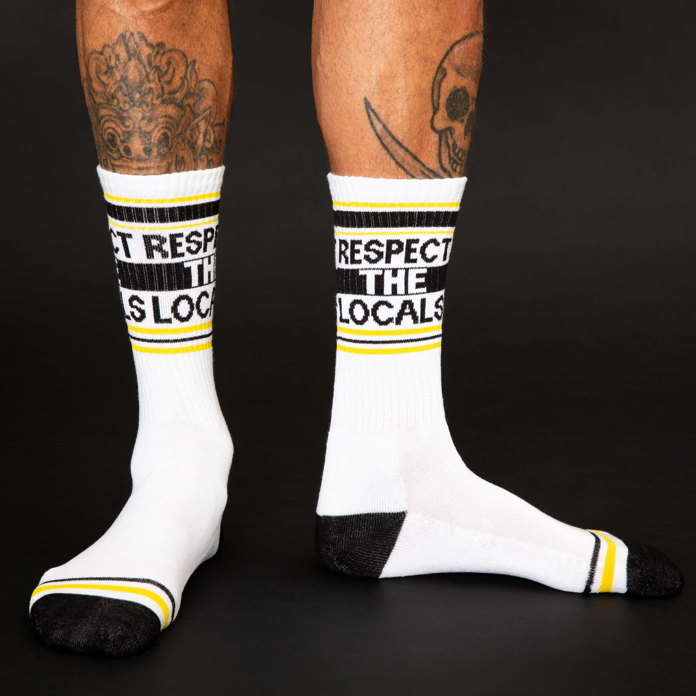 Lifestyle shot: A person's legs wearing the 'Respect The Locals' socks, showcasing the fit and design. [lf]