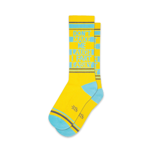 crew length socks in yellow with blue toes, heels, and cuffs feature funny text 