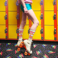 Lifestyle photo: Person wearing 'Here Comes A Roller Skater' socks while roller skating in a retro roller rink. [lf]