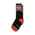 Pair of black crew socks with orange cuffs and white 'Nobody Cares' text. 