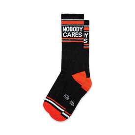 black crew socks with white and orange stripes. "nobody cares" is knitted in white letters on the front. funny socks for men and women.  