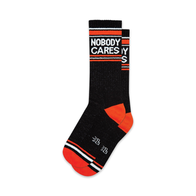 black crew socks with white and orange stripes. "nobody cares" is knitted in white letters on the front. funny socks for men and women.  