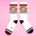 Another flat lay showing both socks, this time laid out to show both sides of the design, on a pink background.