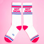 Another flat lay showcasing the 'Hot Mom' socks, this time arranged differently on a pink background.
