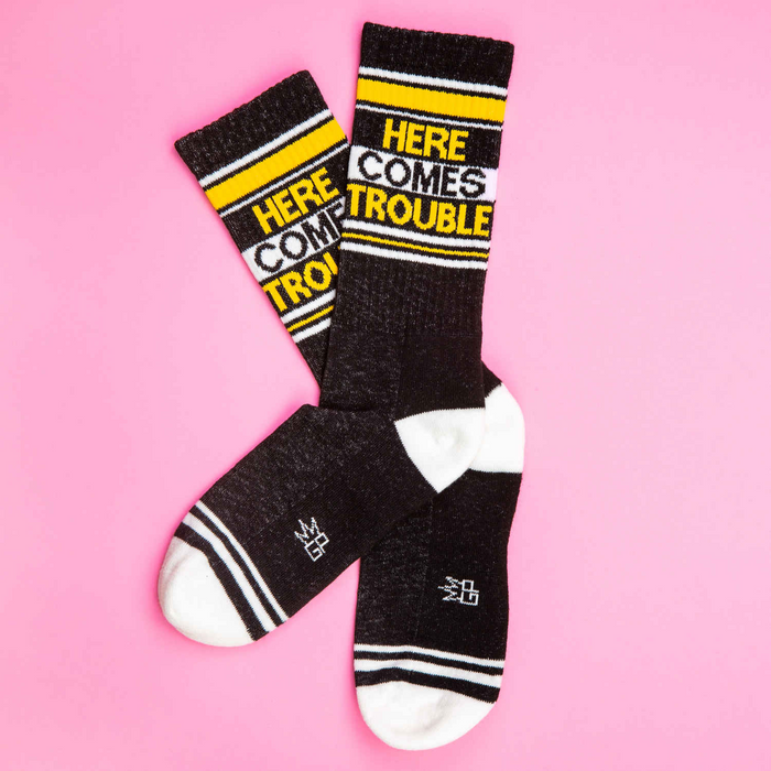 A pair of black socks with white toes, heels, and cuffs. The socks have two wide yellow stripes around the leg and the words 