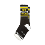 Pair of black crew socks with yellow and white stripes and the text 'HERE COMES TROUBLE' in yellow.