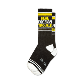 black & white novelty crew socks with yellow stripes and 'here comes trouble' in yellow letters.
