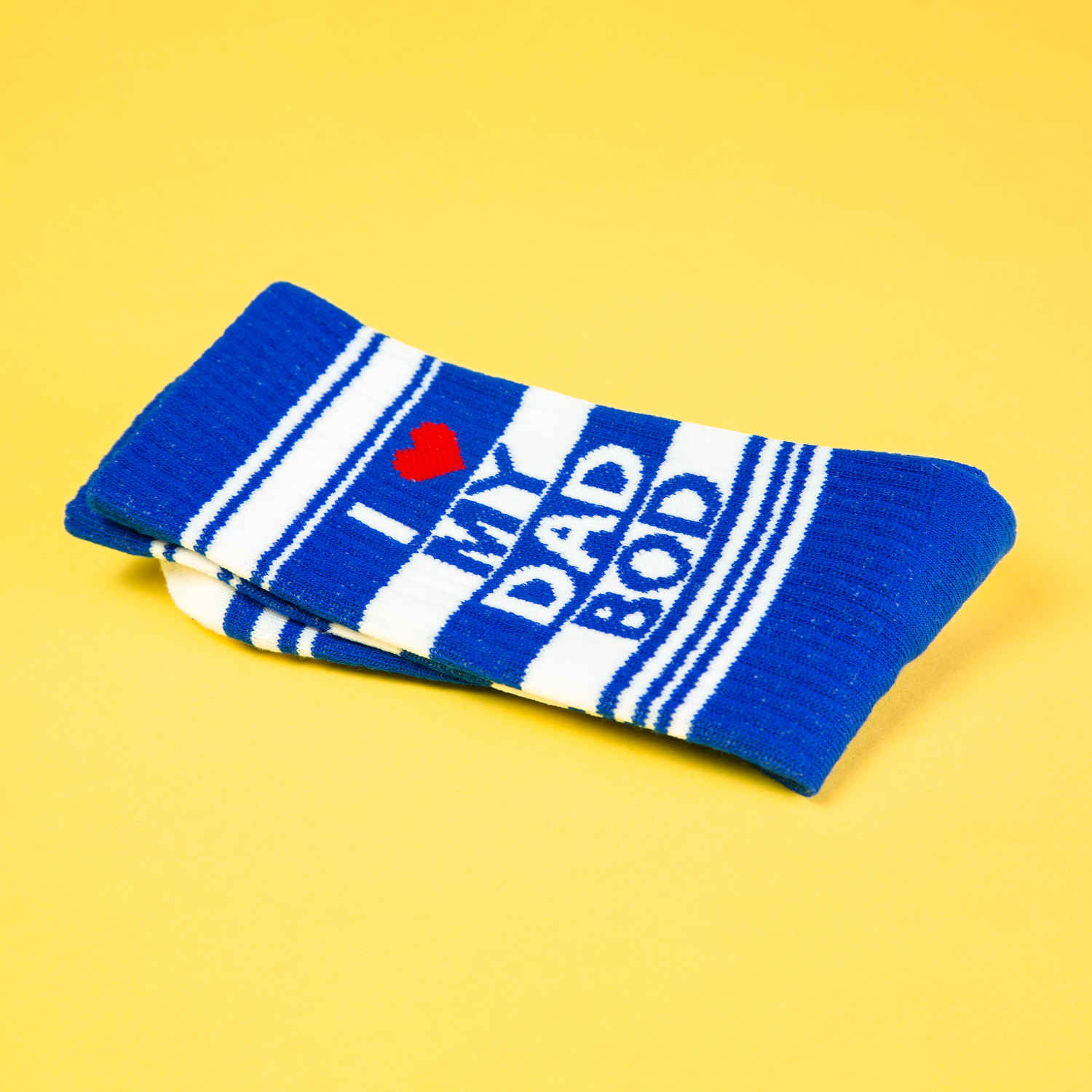Close-up shot of a folded 'I love my dad bod' crew sock, showcasing the design details. Yellow background.