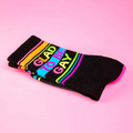 Close-up of a folded 'Glad To Be Gay' sock highlighting the text and stripes on a pink background.