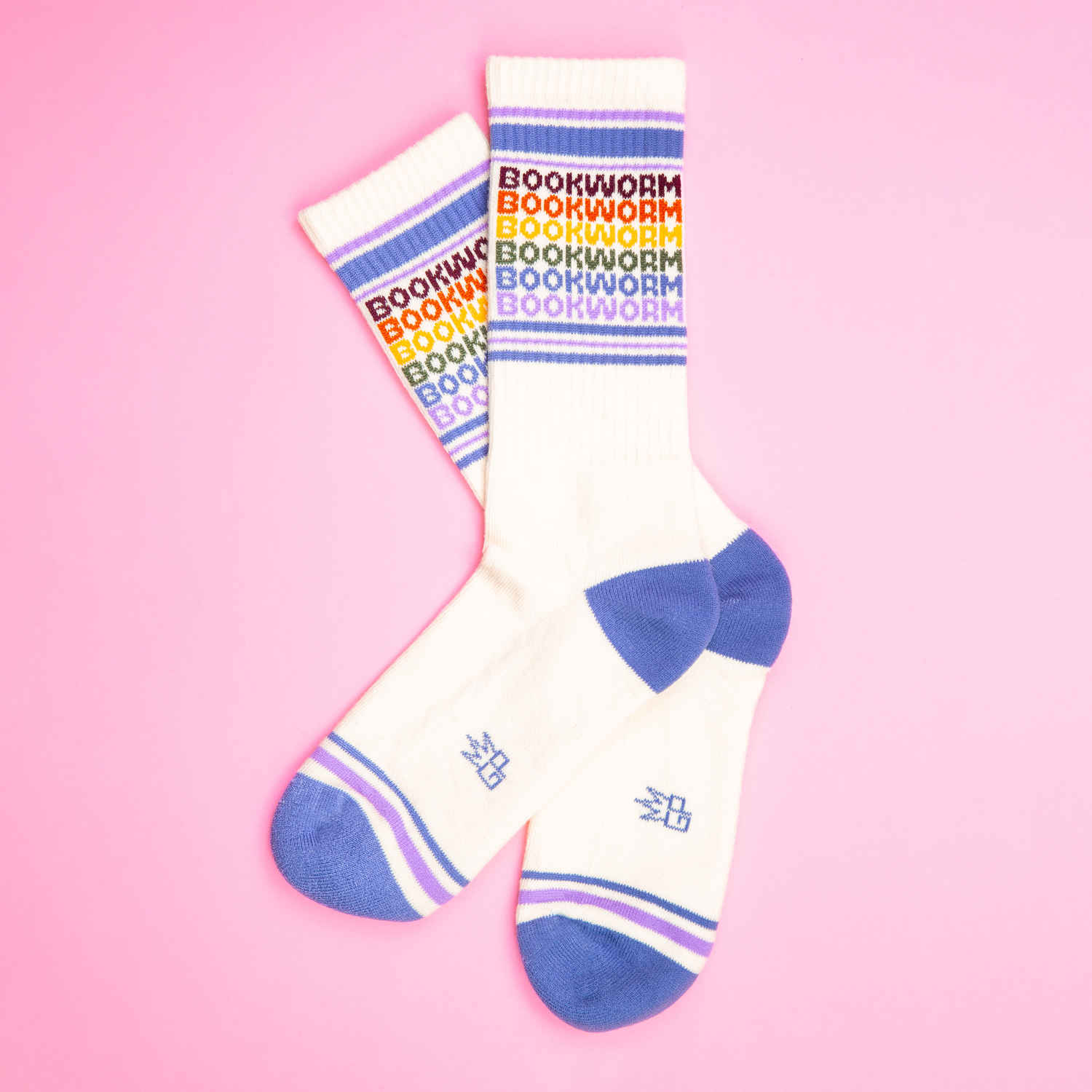 Flat lay product shot of Bookworm socks on a pink background.