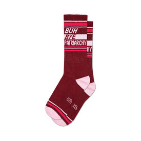 socks that are a dark red color with the words "buh bye patriarchy" in white letters on the leg. the toe and heel are pink, and there are two white stripes near the top of the sock.