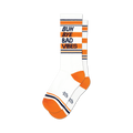 A pair of white crew socks with orange and navy stripes. The socks feature the text 'Buh Bye Bad Vibes' in dark text.