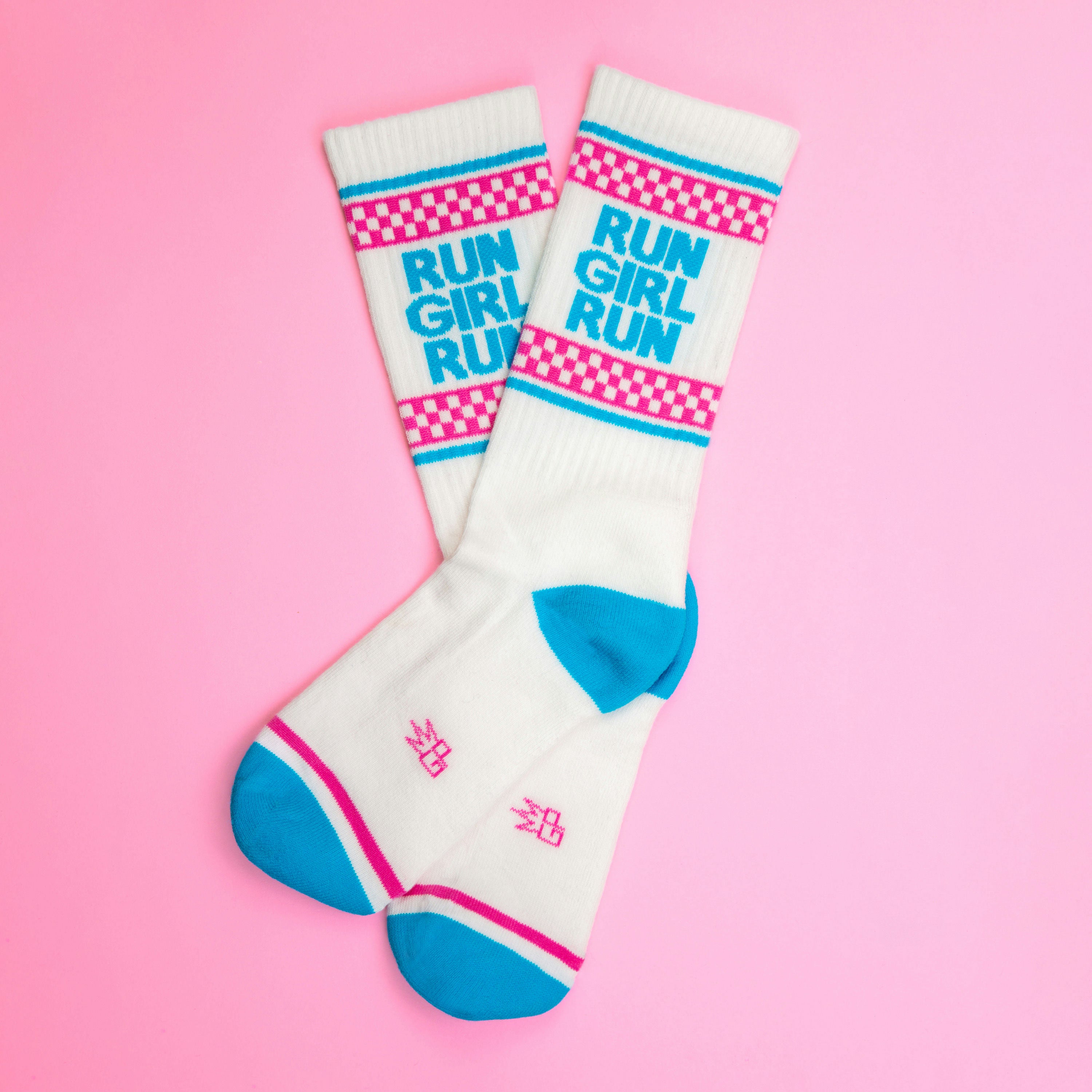 Flatlay of 'Run Girl Run' socks on a pink background. Shows the full design and color scheme. [lf]