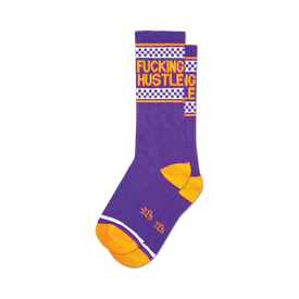 socks that are purple with orange toes, heels, and the word 'hustle' in large letters up the side of the leg. the word 'fucking' is more subtly woven into the fabric and is only visible upon close inspection.