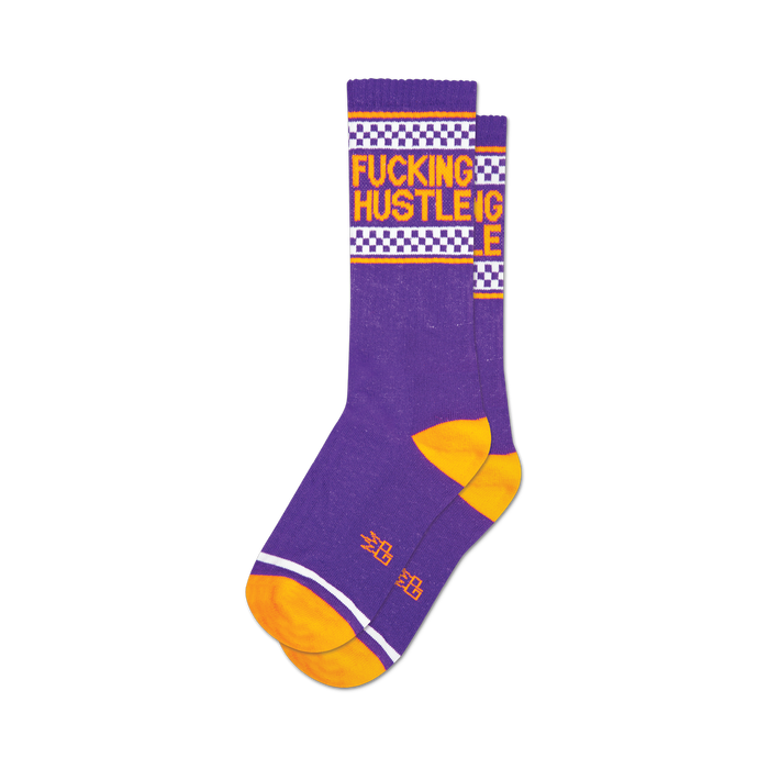 socks that are purple with orange toes, heels, and the word 'hustle' in large letters up the side of the leg. the word 'fucking' is more subtly woven into the fabric and is only visible upon close inspection. }}