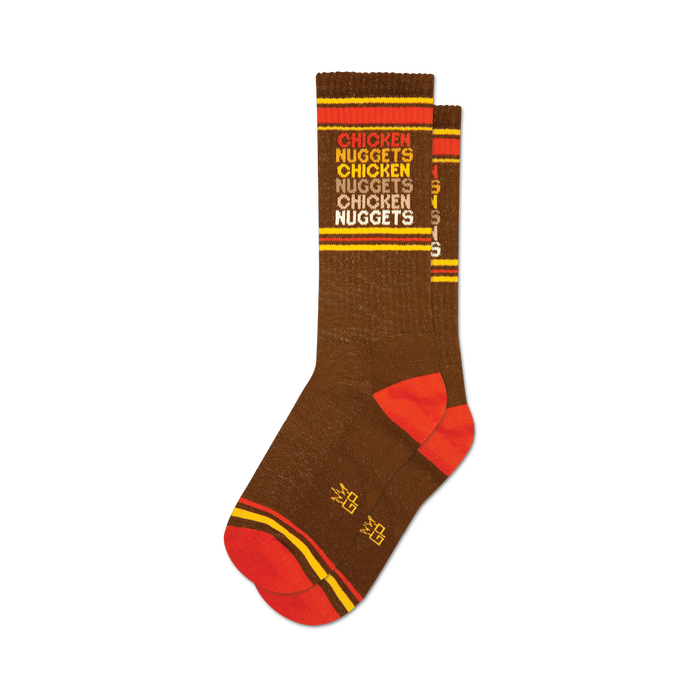 socks that are brown with red and orange stripes at the top and bottom. the word 'chicken nuggets' is repeated vertically in orange and yellow text. }}