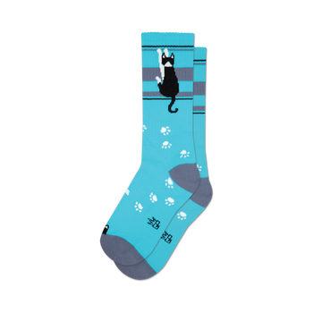 socks that are blue with a tuxedo cat wearing a bow tie on the front. the cat is black with white paws and a white tip on its tail. the socks also have gray toes and heels.