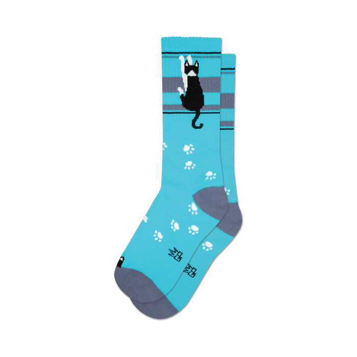 socks that are blue with a tuxedo cat wearing a bow tie on the front. the cat is black with white paws and a white tip on its tail. the socks also have gray toes and heels. }}