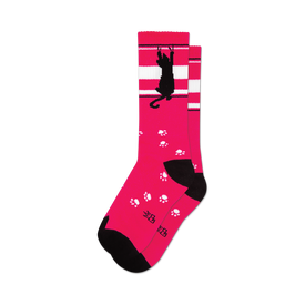 socks that are pink with a black cat and white stripes near the top. the black cat is hanging from the white stripes with one paw and has a paw print by its other paw. there are also paw prints all over the socks.