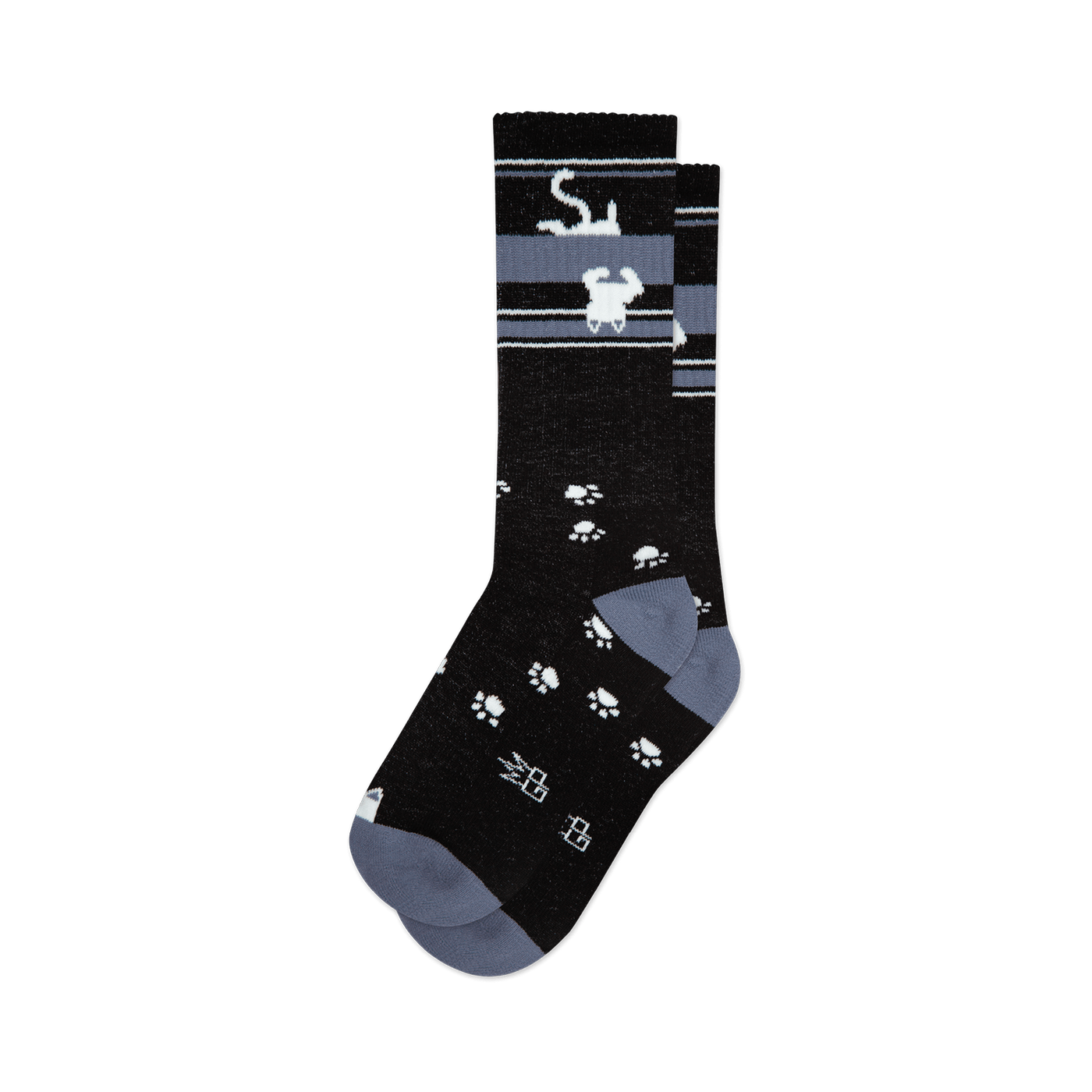 Pair of black crew socks with a grey stripe featuring upside-down white cats and scattered white paw prints. 