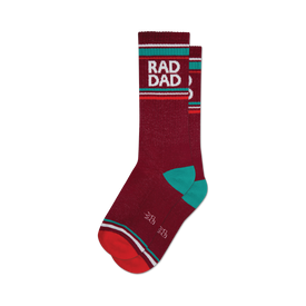 a pair of socks with the words 'rad dad' in large, white letters on a red background. socks that are dark red with white and teal stripes at the top and a red toe and heel.
