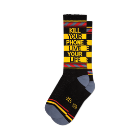 a pair of black socks with yellow and red stripes at the top and the words 'kill your phone live your life' in yellow letters on the front.