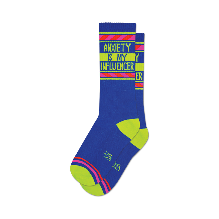 a pair of blue socks with the words 'anxiety is my influencer' in yellow and pink. }}